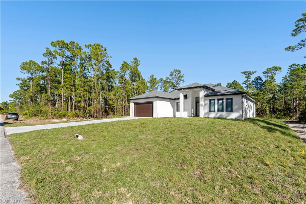 Contemporary white stucco exterior with a dark shingle roof