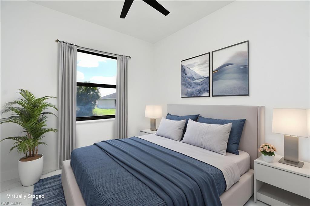Bright bedroom featuring a large window with privacy curtains, a ceiling fan, and ample wall space