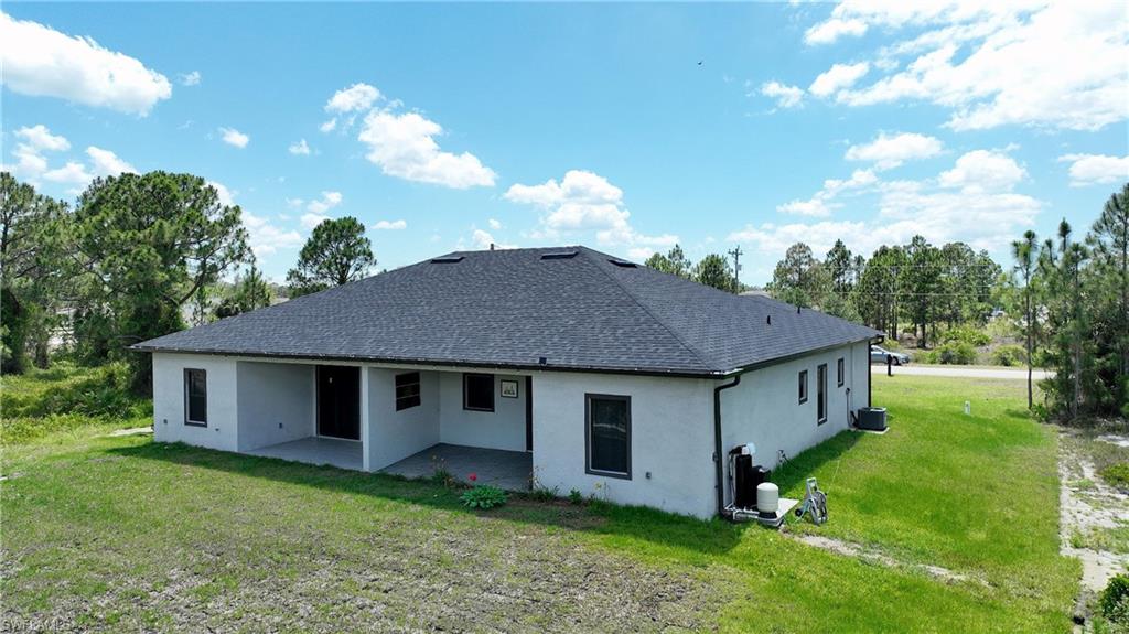 Contemporary exterior featuring a dark asphalt shingle roof, white stucco siding, and black-framed windows