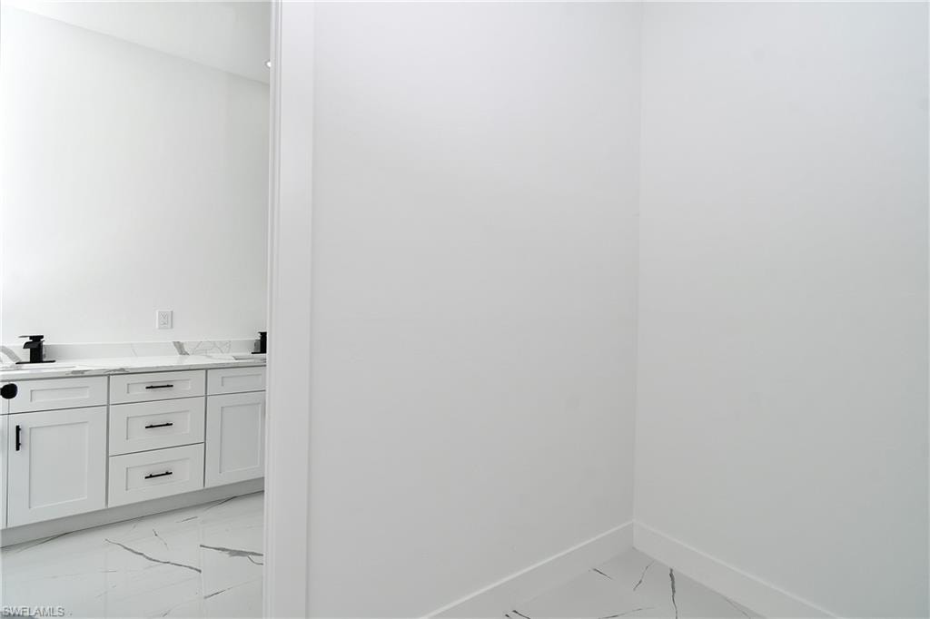 Double vanity with white shaker-style cabinetry, quartz countertop, and black fixtures