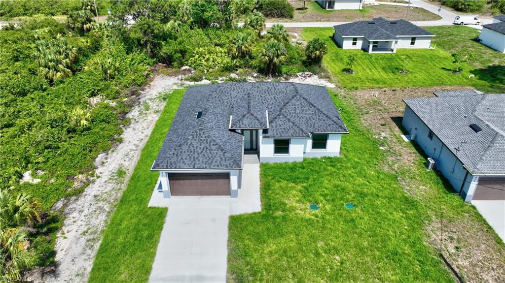 Newly constructed property featuring a dark shingle roof and a two-car garage