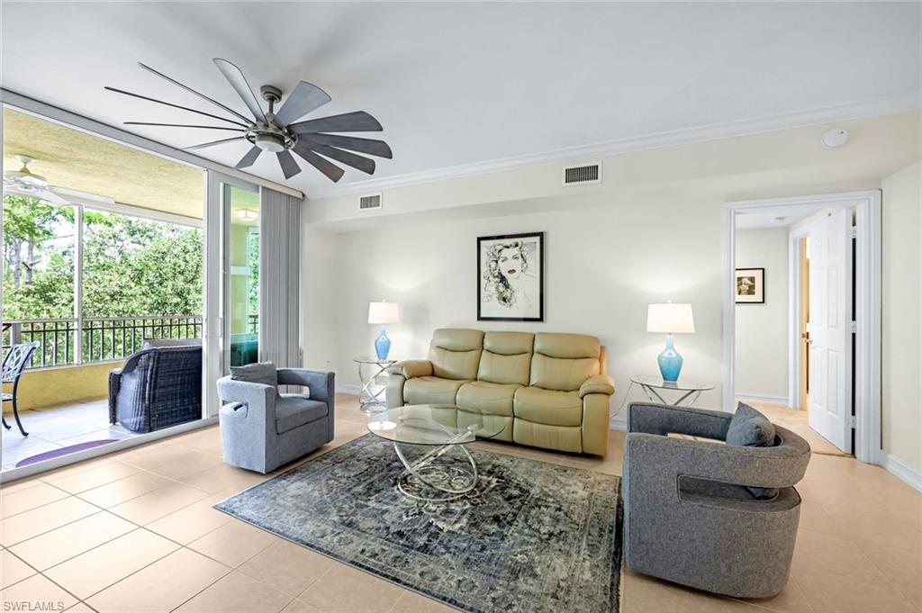 Living room with light tile patterned flooring, ornamental molding, and ceiling fan