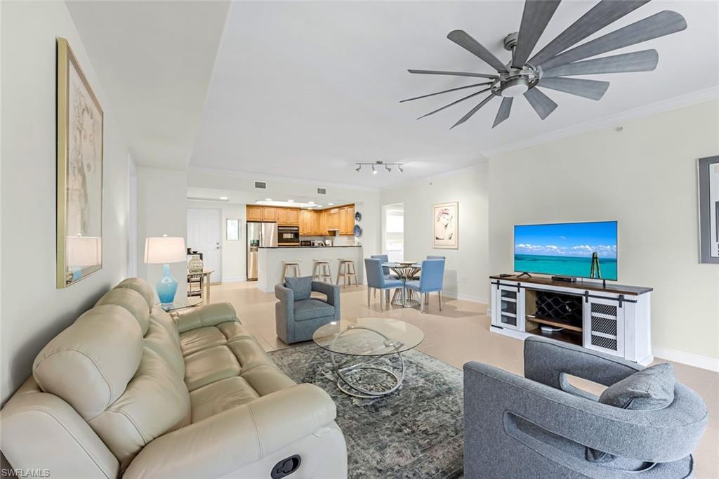 Living room featuring ornamental molding, rail lighting, and ceiling fan