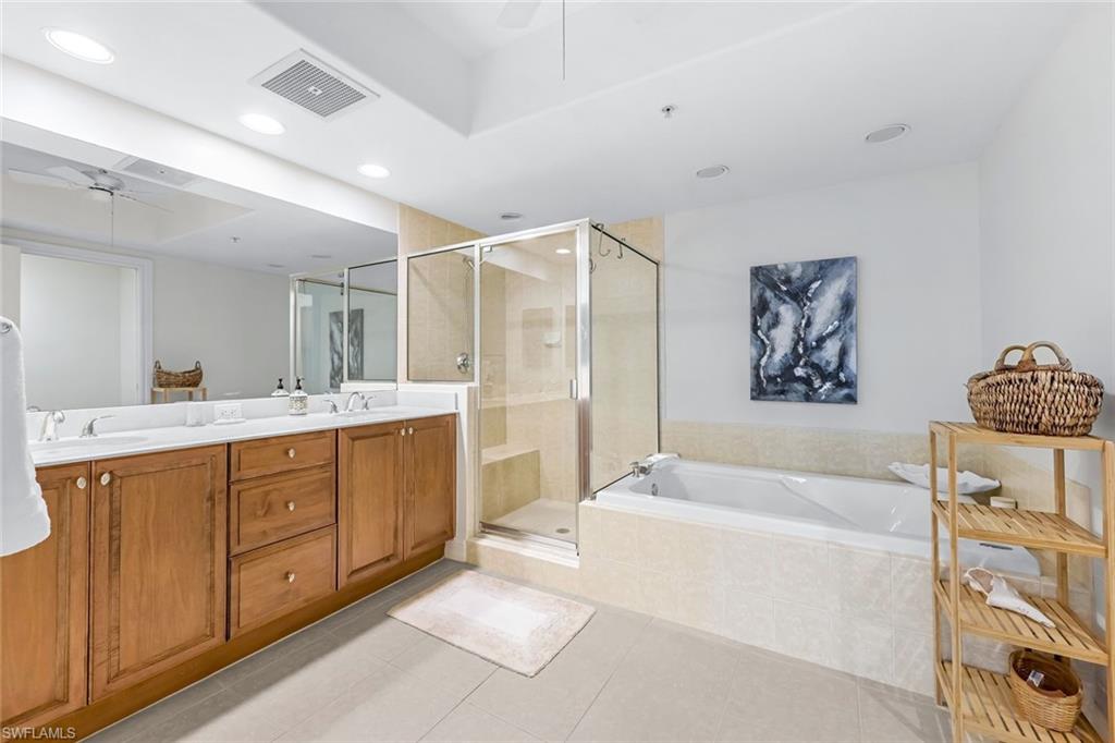 Bathroom with shower with separate bathtub, ceiling fan, double sink vanity, and tile patterned flooring