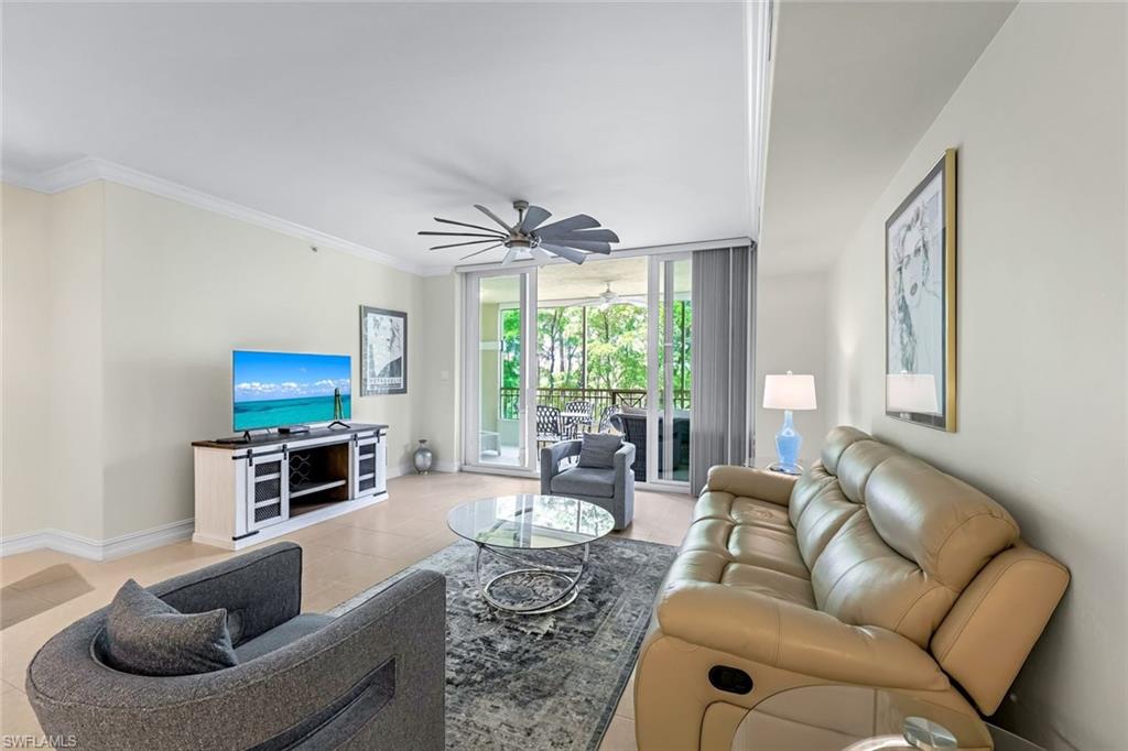 Tiled living room featuring crown molding and ceiling fan