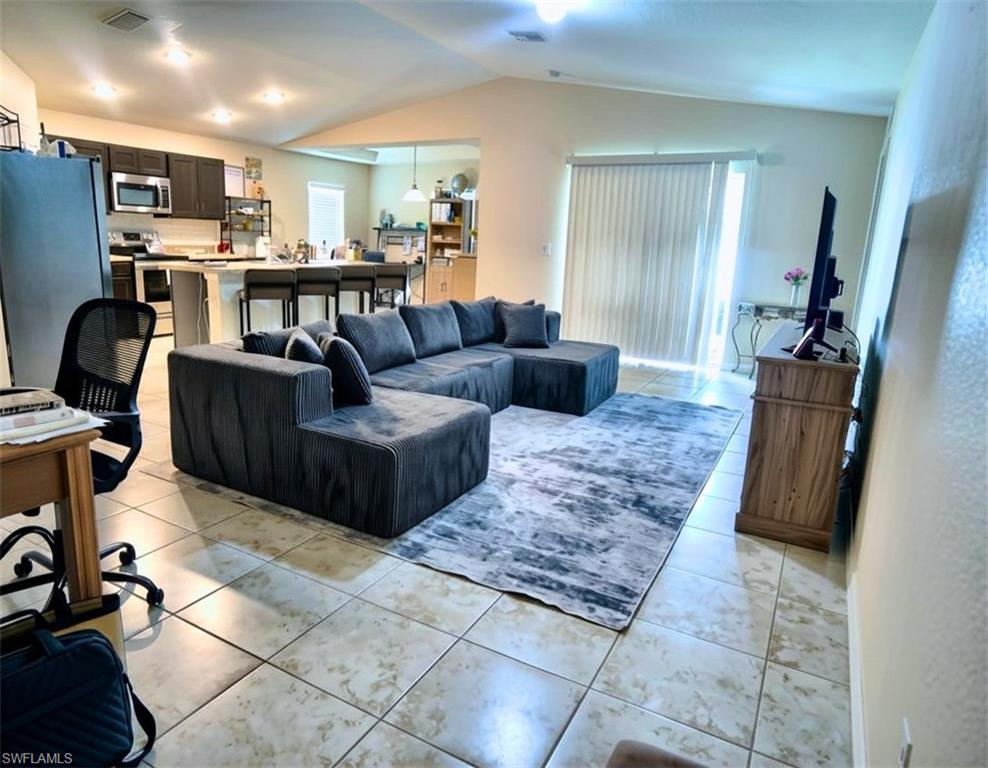 Open-concept living space featuring vaulted ceilings and recessed lighting