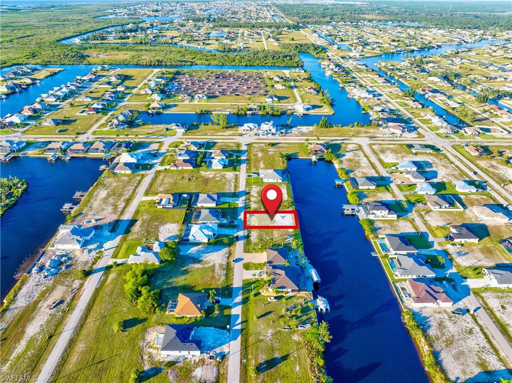 Waterfront parcel featuring direct canal access, a surrounding residential area, and a clear, buildable lot
