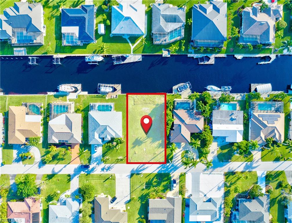 Grassed waterfront lot featuring canal access, dock potential, and a residential street frontage