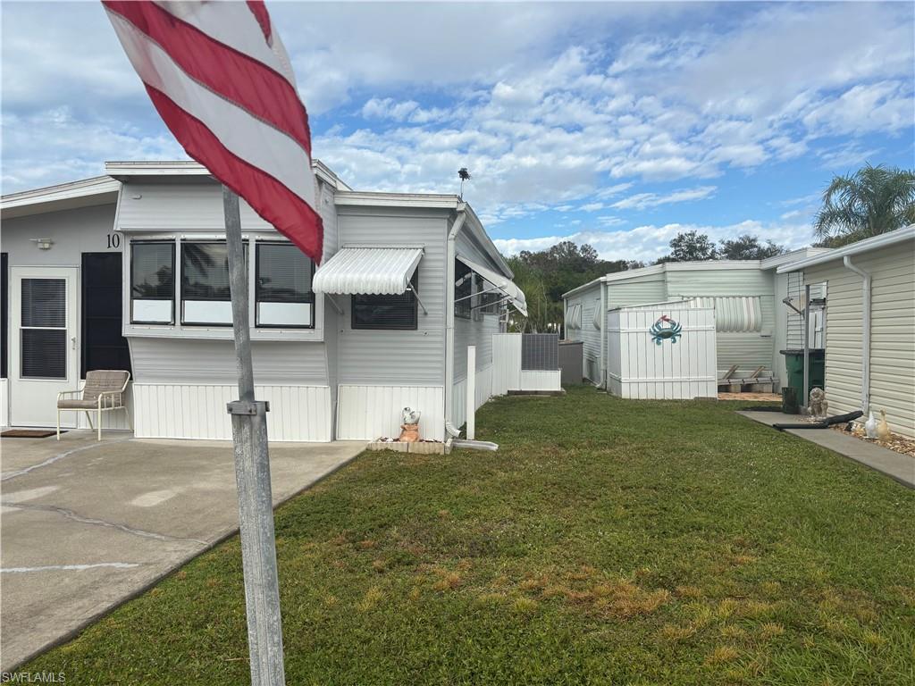 View of side of property featuring a lawn