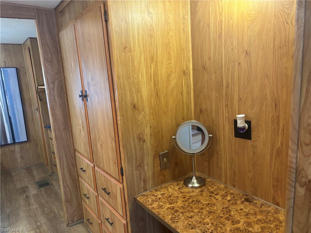 Bathroom with wood walls, wood finished floors, and vanity
