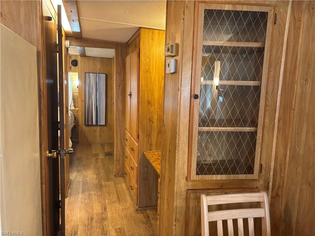 Hallway featuring wood finished floors and wooden walls
