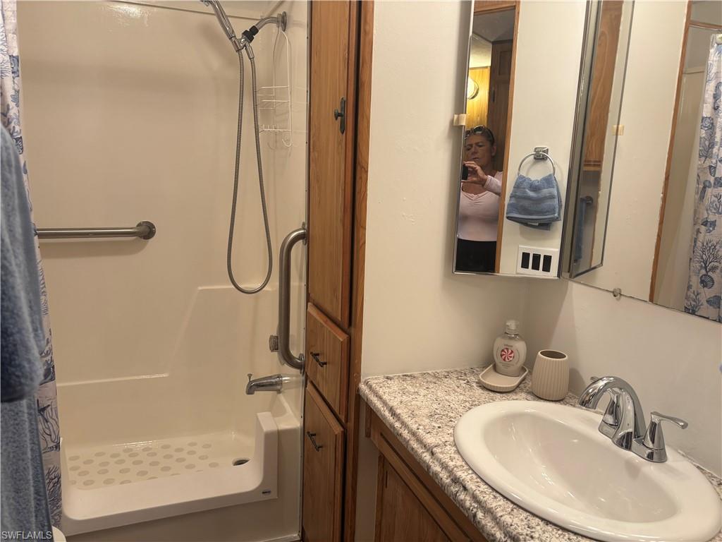 Bathroom with a shower with curtain and vanity