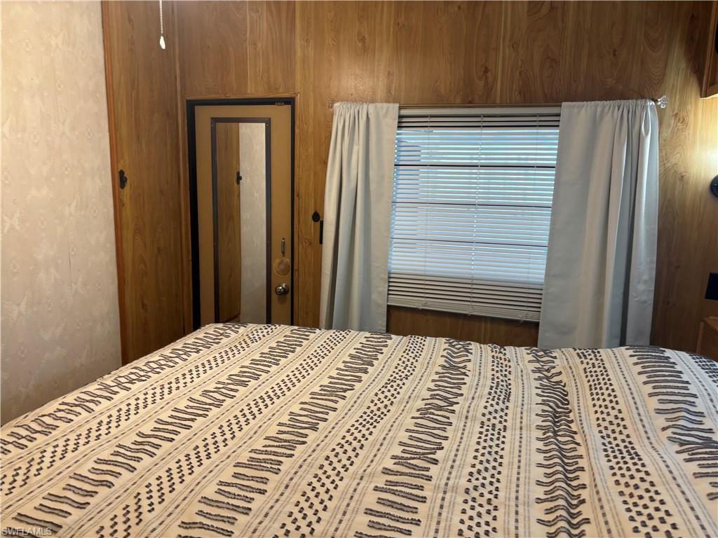 Bedroom featuring wood walls