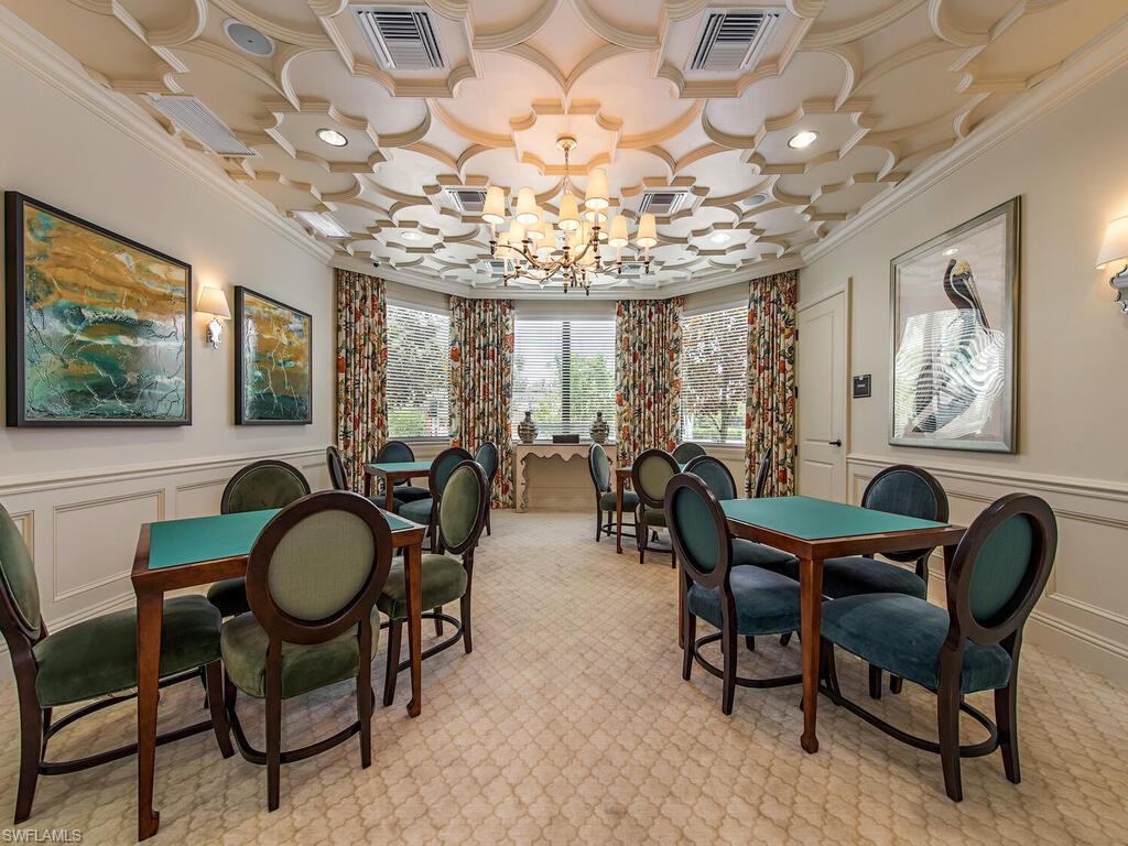 Dining area with a notable chandelier, light colored carpet, and ornamental molding
