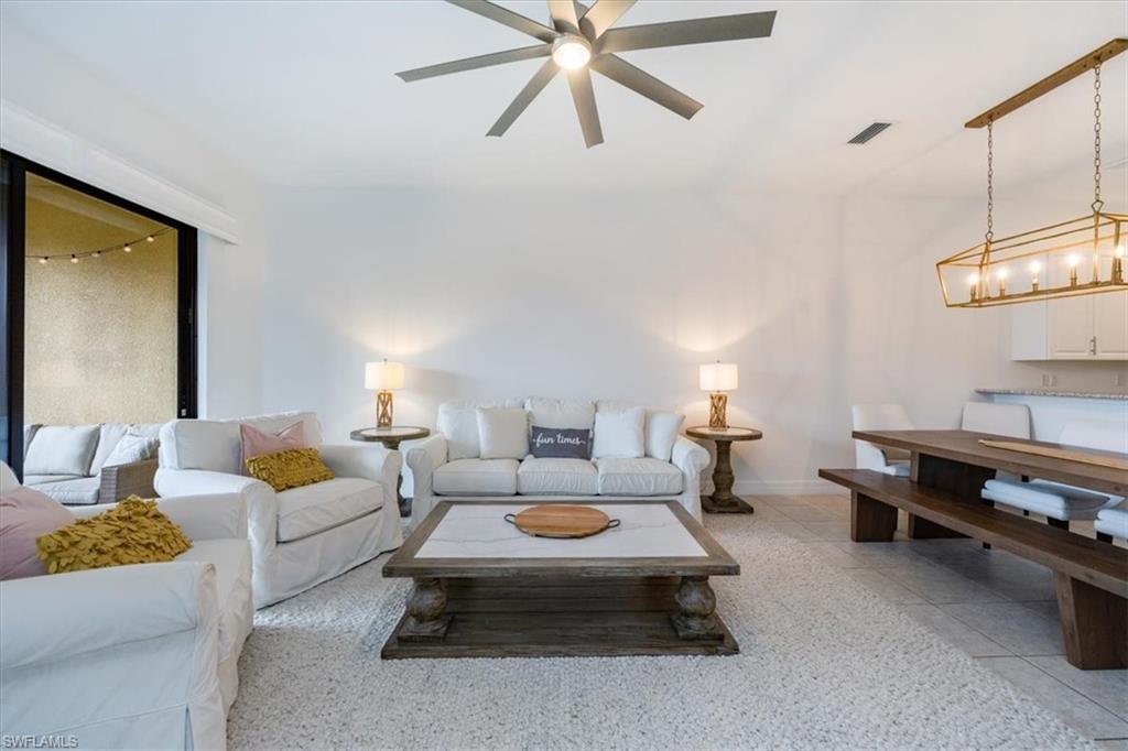 Living room with ceiling fan and light tile patterned floors