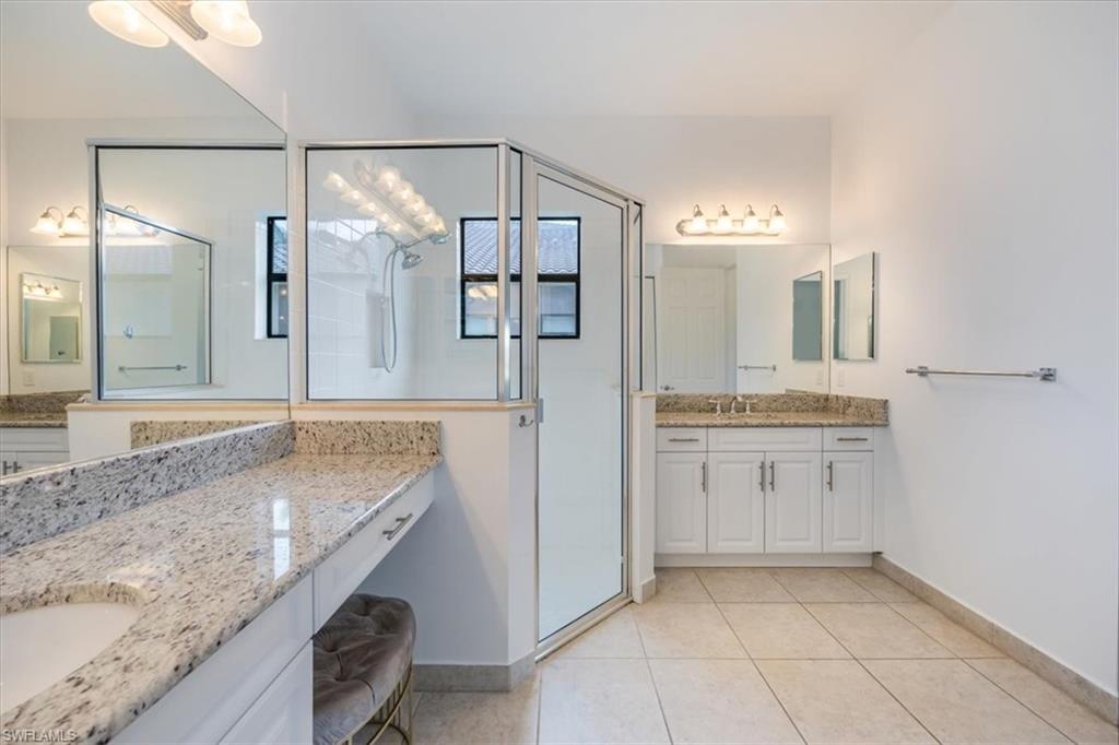 Bathroom featuring tile patterned flooring, an enclosed shower, and vanity