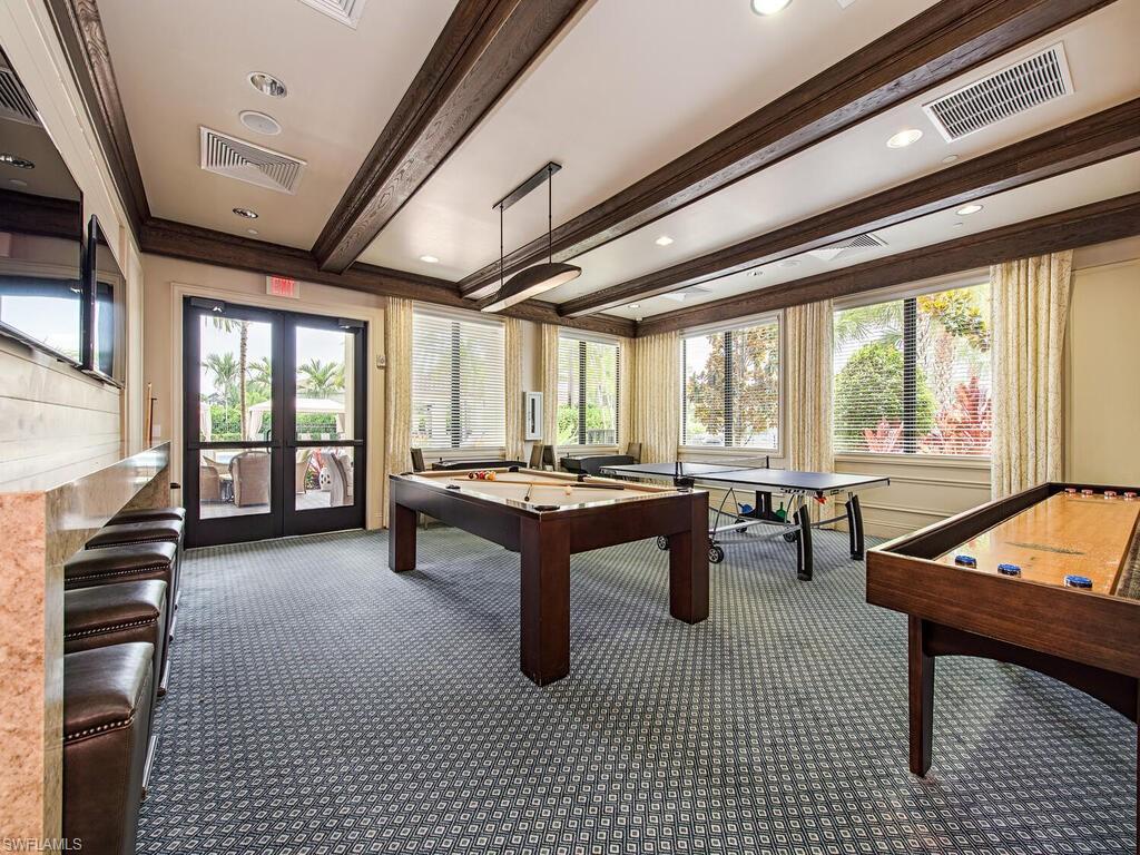 Game room featuring dark colored carpet, pool table, crown molding, french doors, and beam ceiling