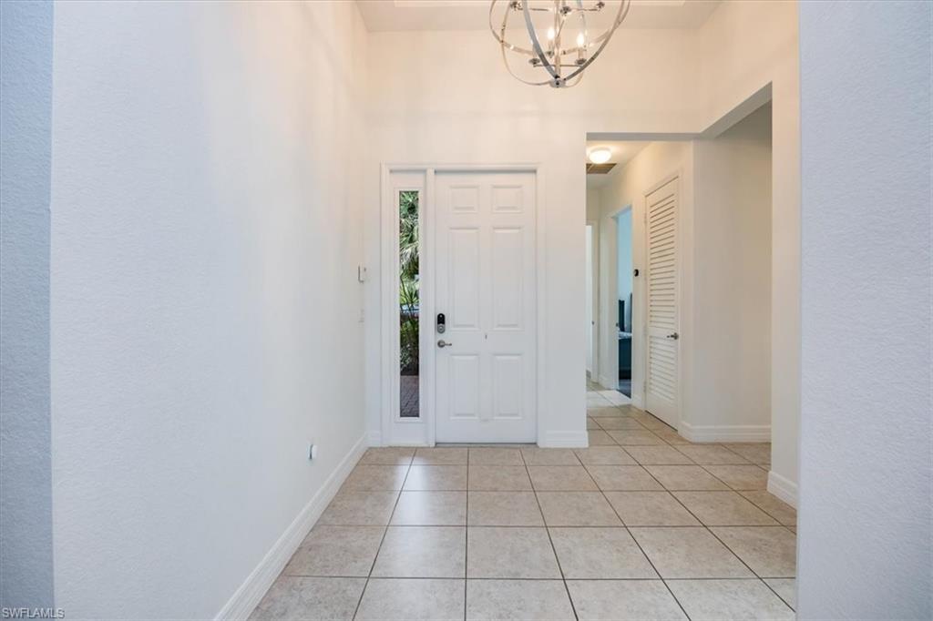 Tiled foyer featuring a towering ceiling and a chandelier