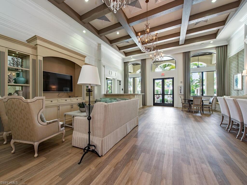 Living room with an inviting chandelier, beamed ceiling, french doors, wood-type flooring, and coffered ceiling