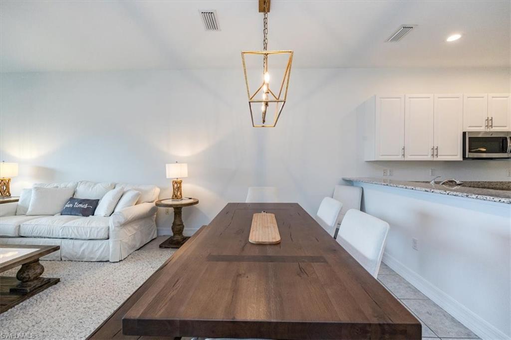 Dining area featuring light tile patterned flooring and a chandelier