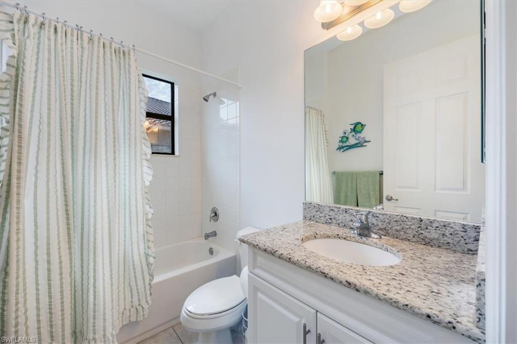 Full bathroom with toilet, tile patterned flooring, shower / bath combo, and vanity