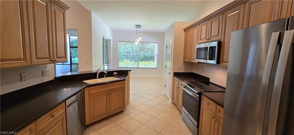 Kitchen featuring stainless steel appliances,  large dining area and a breakfast bar.