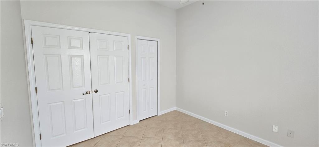 Third bedroom featuring light tile flooring and closet