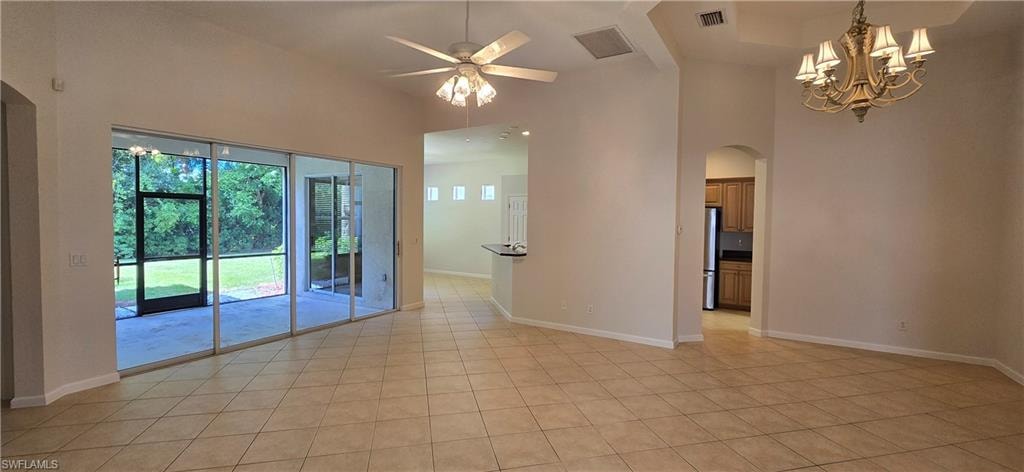 Features ceiling fan, a towering ceiling, arched walkways, tile flooring