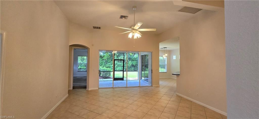 Living Room with ceiling fan, arched walkways, and light tile patterned floors