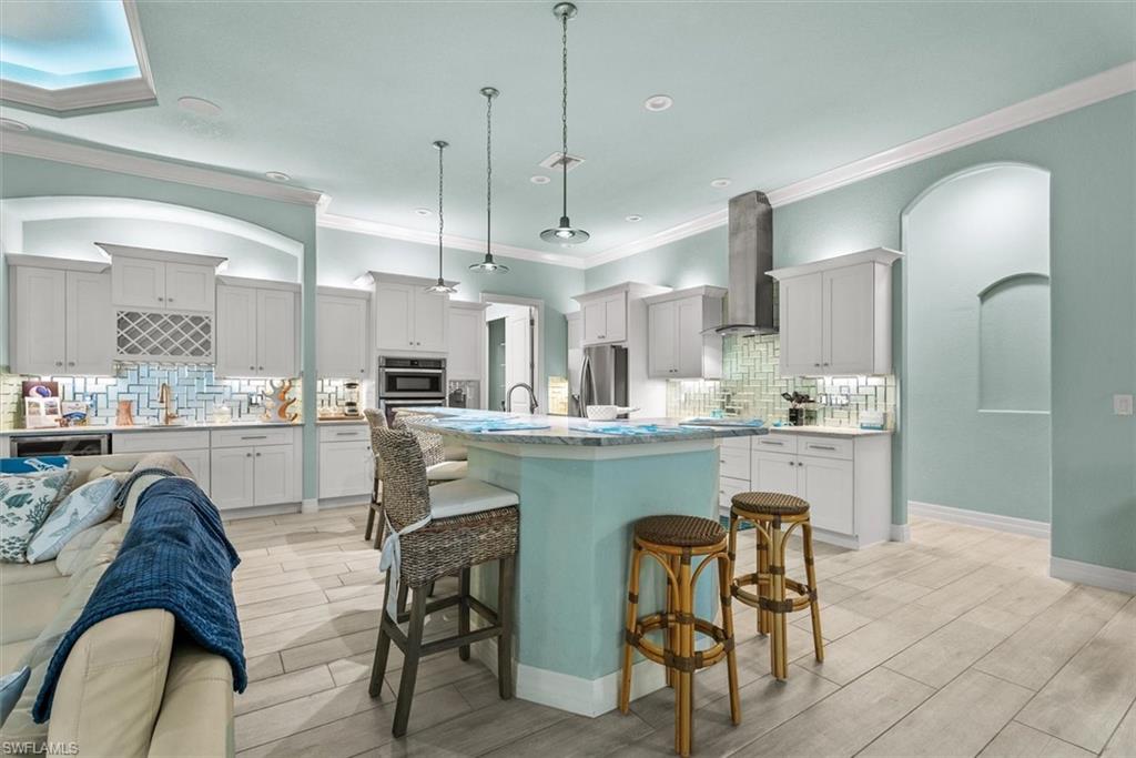 Spacious kitchen with a central island featuring a light blue base and a light-colored countertop