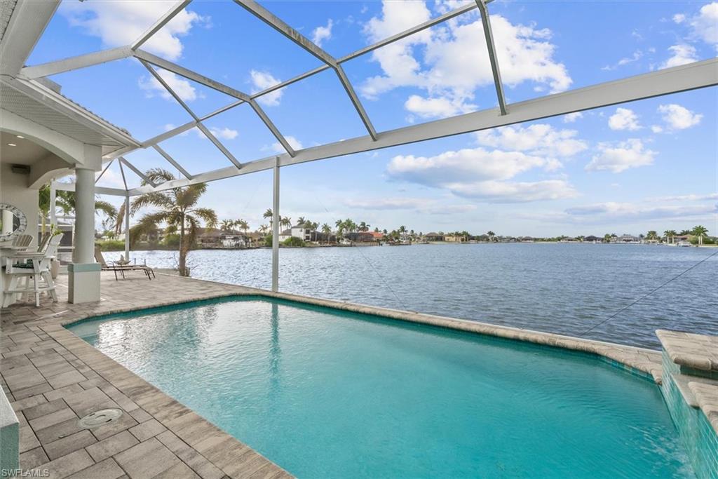 Screened outdoor living area featuring a rectangular pool and expansive water frontage