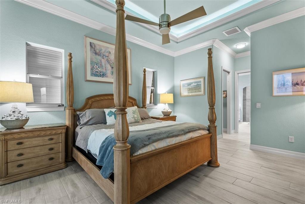 Spacious room featuring wood-finish flooring, light blue wall tones, and white crown molding