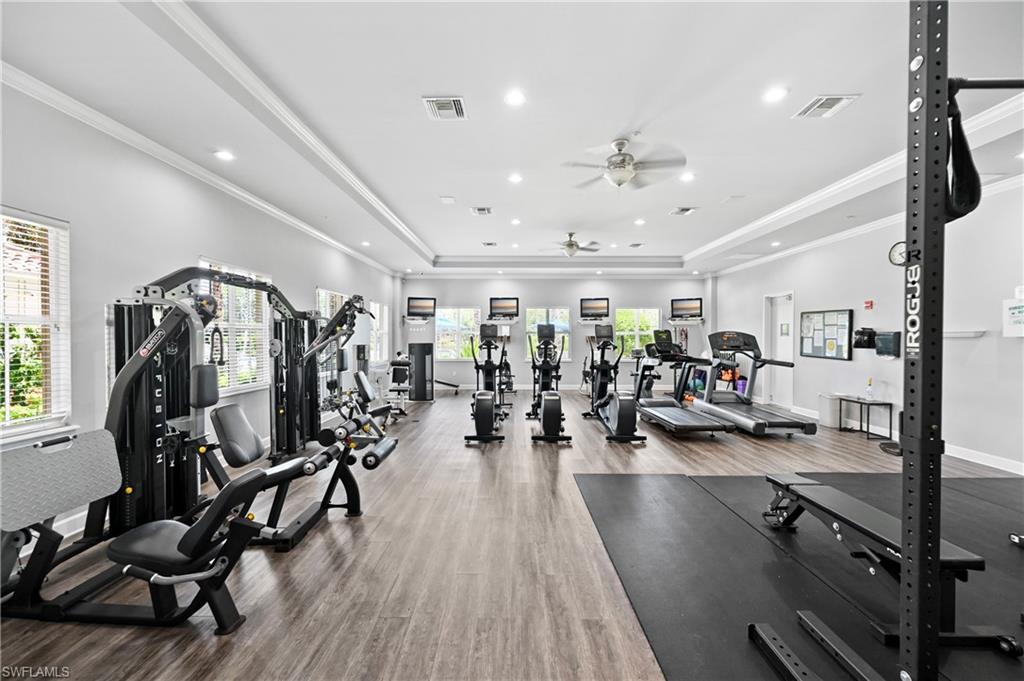 Spacious fitness area featuring wood-finish flooring, recessed lighting, and multiple ceiling fans