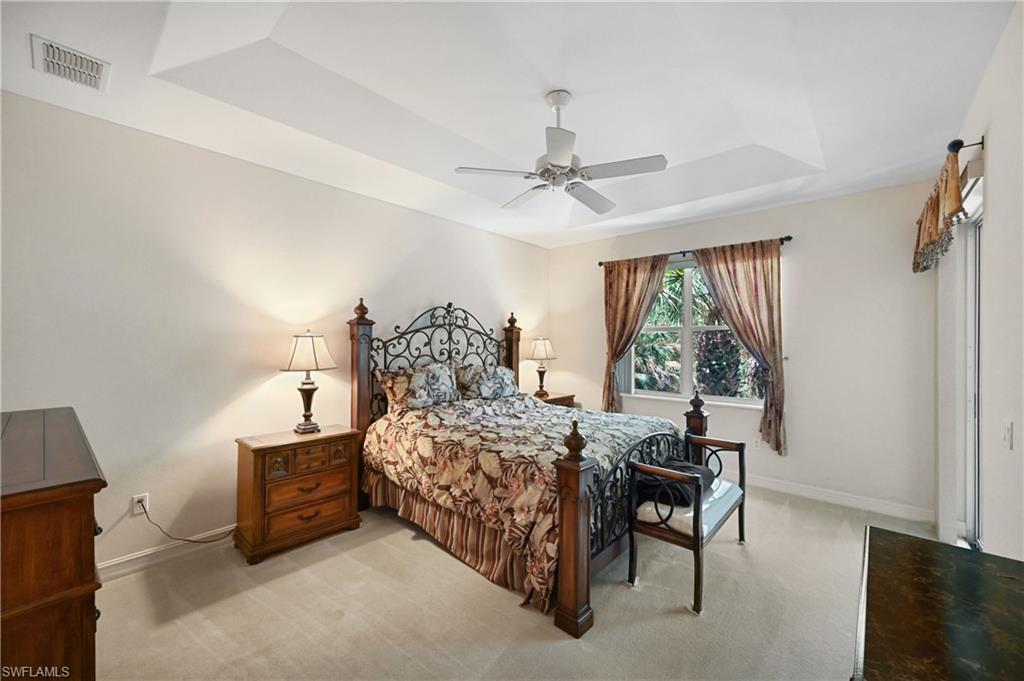 Tray ceiling with recessed lighting, ceiling fan, large window, and direct outdoor access