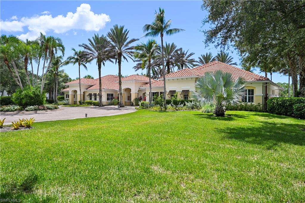 Mediterranean-style exterior with a terracotta tile roof, stucco finish, and multiple windows with awnings