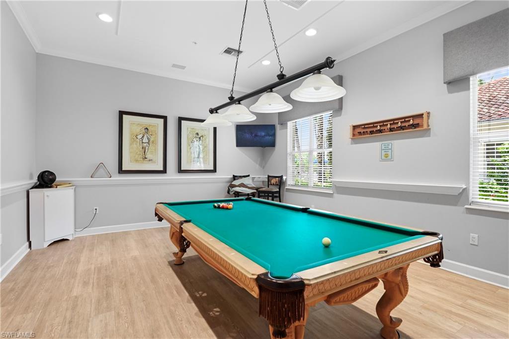 Recessed lighting, wood-finish flooring, two windows with blinds, crown molding, and a built-in wall shelf