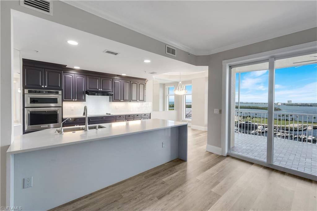 Kitchen featuring dark cabinetry, stainless steel appliances, and a light-toned countertop