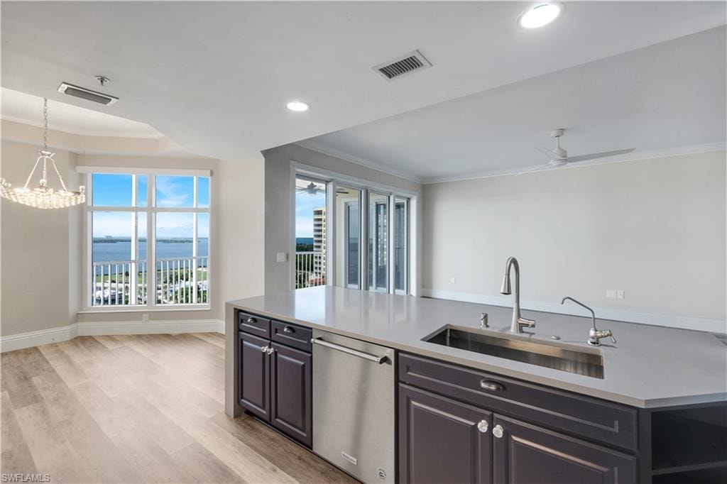 Gourmet kitchen island with an undermount stainless steel sink, pull-down faucet, integrated dishwasher, and ample counter space