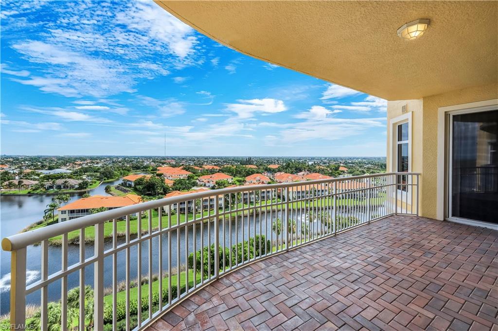Expansive front, curved balcony featuring fountain and neighborhood views, brick paver flooring and sliding glass doors leading into BR2, Den, and BR3