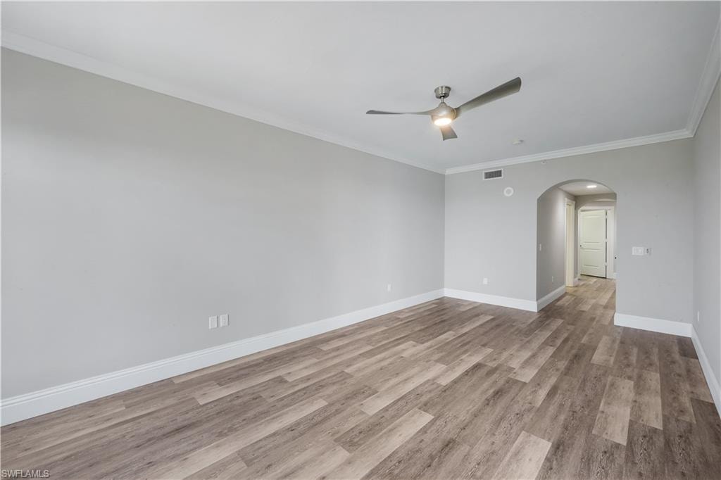 Spacious primary suite with waterfront views featuring wood-finish flooring, a contemporary ceiling fan, and crown molding
