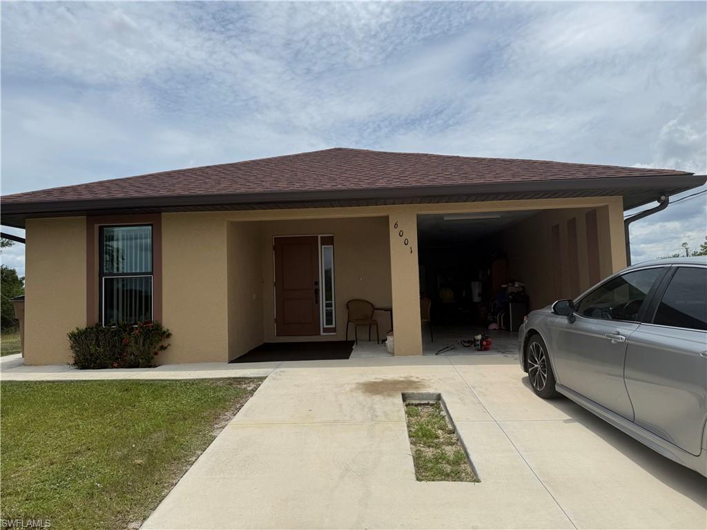 Tan stucco exterior with brown trim, featuring a dark brown front door with sidelight