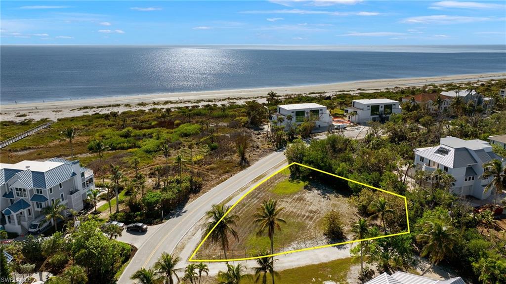 Aerial perspective of suburban area featuring expansive coastline and property parcel outlined