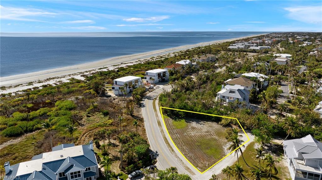Aerial view of residential area featuring property boundaries highlighted and expansive coastline