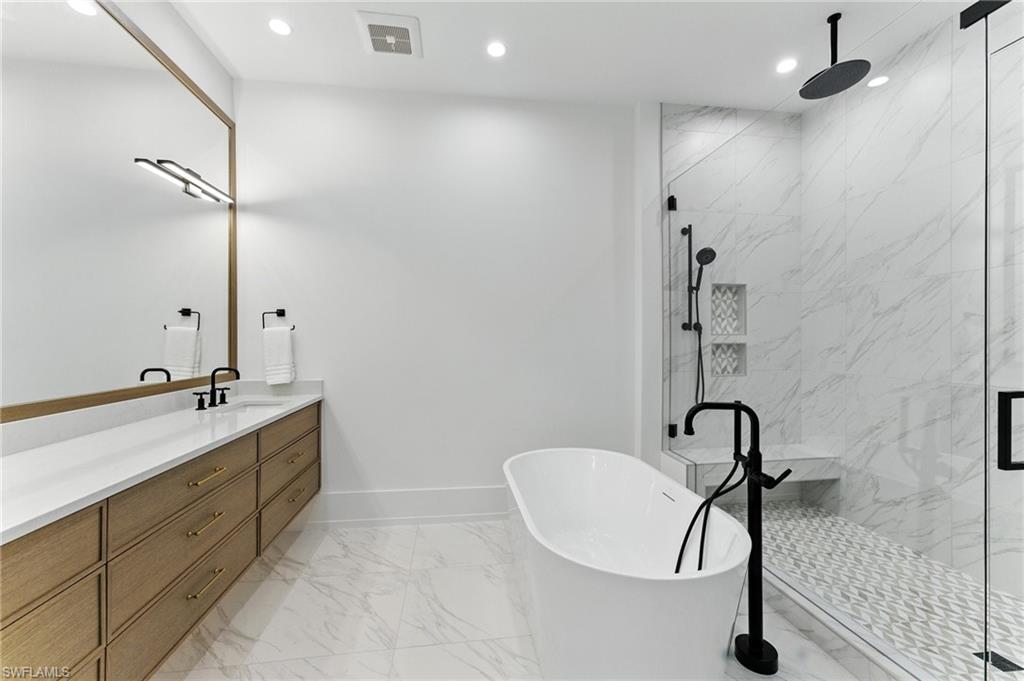 Bathroom with marble finish flooring, a soaking tub, vanity, a marble finish shower, and recessed lighting