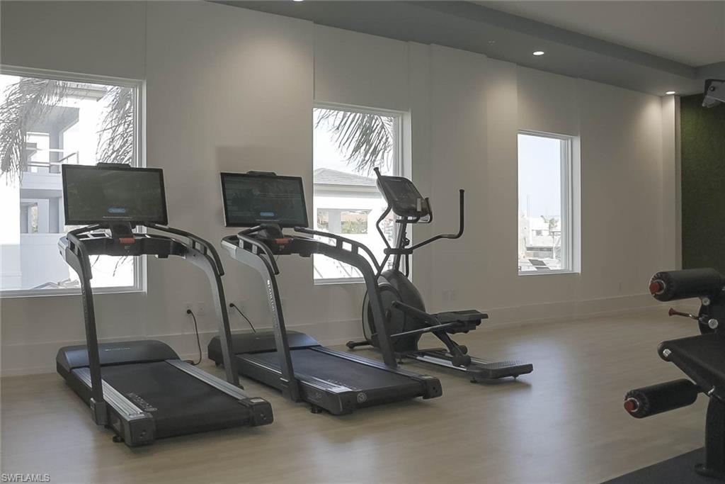 Workout area featuring wood finished floors, plenty of natural light, and recessed lighting