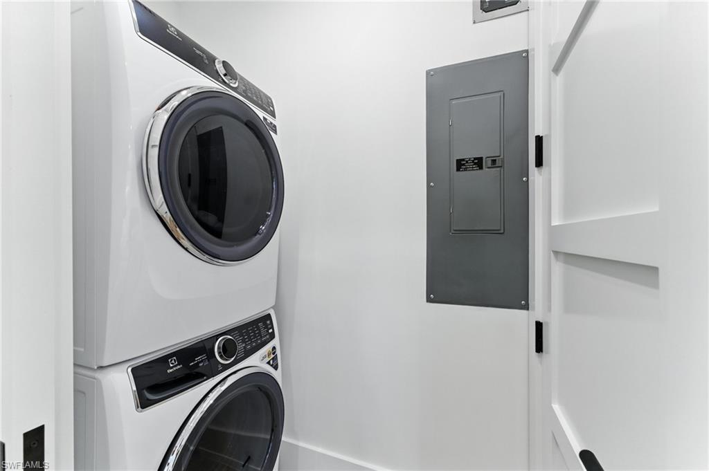Laundry area with stacked washer / drying machine and electric panel