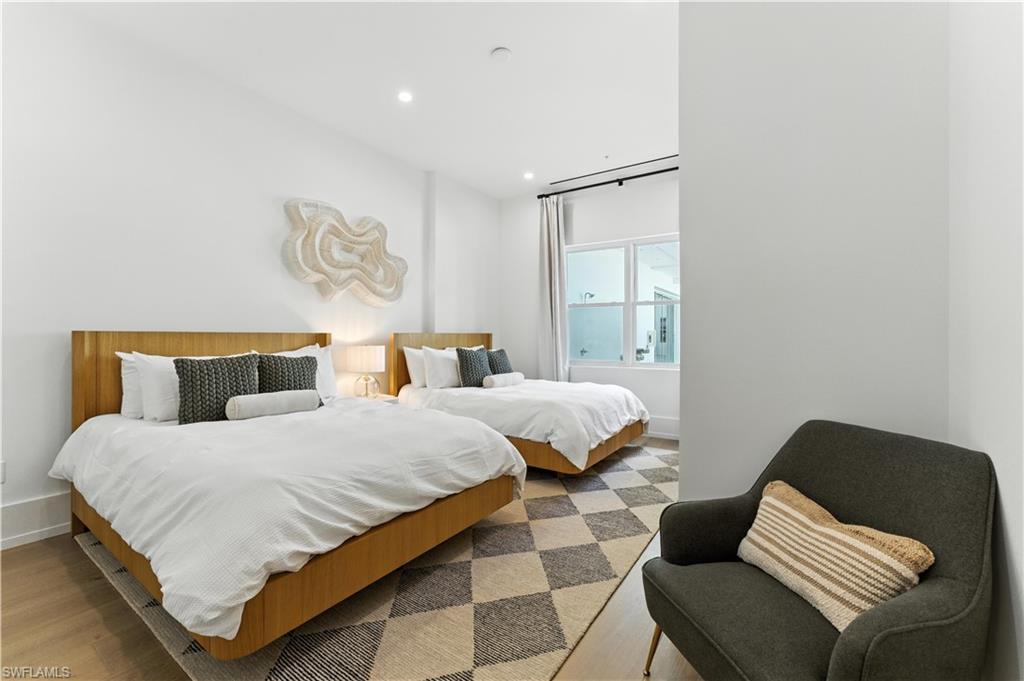 Bedroom with light flooring and recessed lighting - two queen beds and  large window with Southern exposure
