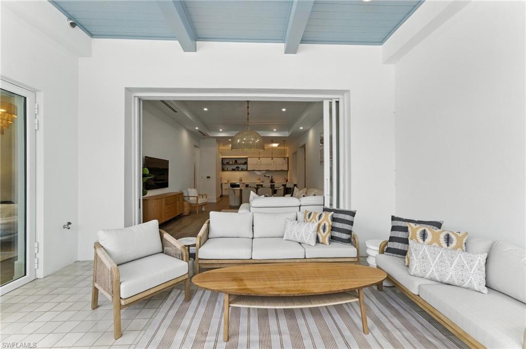 Living room with recessed lighting, a chandelier, and a wooden ceiling with exposed beams