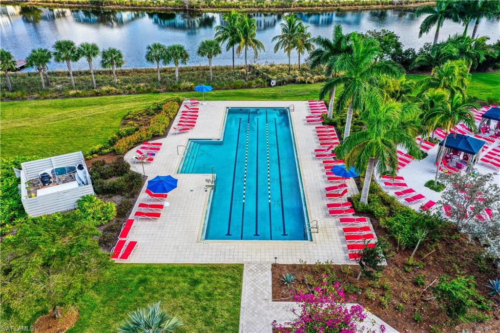 View of swimming pool featuring a lawn and a water view