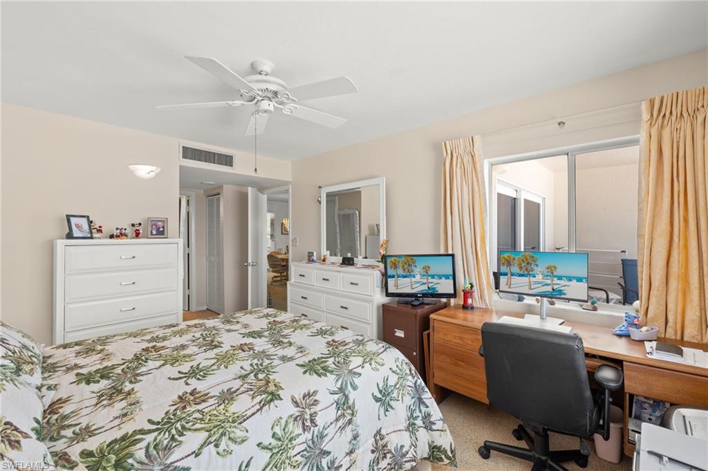 Spacious room featuring a ceiling fan, a large window with sliding glass doors, and light-colored walls